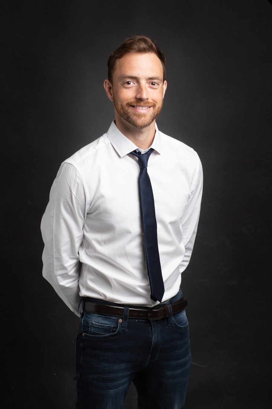 Felipe Rebello, smiling, in a white shirt and navy tie